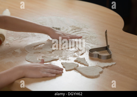 A young girl rolling out dough for cookies Stock Photo