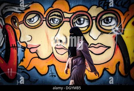 Gaza, Palestinian territories, . 28th Oct, 2013. A Palestinian woman wearing a niqab walks in front ofmural painting in Gaza City, on October 28, 2013.Photo: Majdi Fathi/NurPhoto Credit:  Majdi Fathi/NurPhoto/ZUMAPRESS.com/Alamy Live News Stock Photo