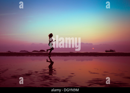 wellbeing or sport background, woman silhouette on the beach Stock Photo