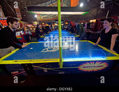 Playing a game of air hockey in an arcade on Brighton Pier Stock Photo