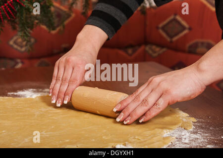 Woman's hands rolling dough with a rolling pin Stock Photo