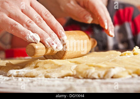 Woman's hands rolling dough with a rolling pin Stock Photo