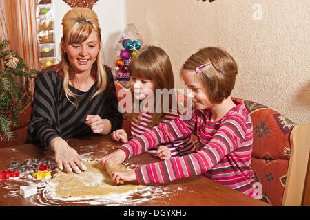 Mother with children, twin girls baking biscuits Stock Photo