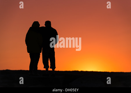 Senior couple enjoys the sunset from a jetty. Stock Photo