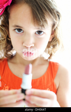 Mixed race girl playing with lipstick Stock Photo