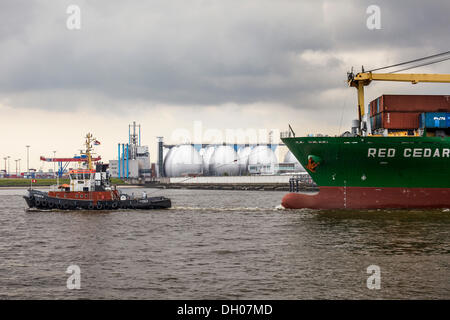 Tug boat towing a container ship on the Elbe, Hamburg Stock Photo