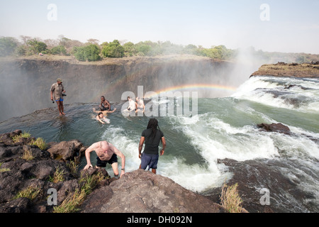 Tourists swimming in Devils Pool on the edge of the Victoria Falls, Zambia side, Africa Stock Photo