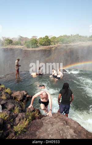 Devils Pool Victoria Falls; Zambia side, people on an adventure holiday swimming on the edge of the Falls in Devil's Pool, Zambia Africa Stock Photo