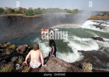 Zamnia tourists; People swimming in Devils Pool at the edge of the Victoria Falls, Adventure travel in Zambia Africa Stock Photo