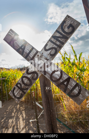 Antique Country Rail Road Crossing Sign Near a Corn Field in a Rustic Outdoor Setting. Stock Photo