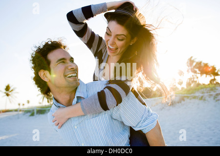 Hispanic couple playing on beach Stock Photo