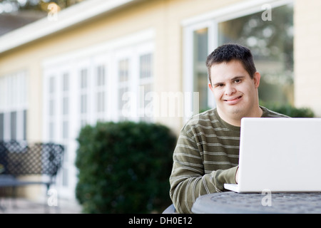 Disabled Caucasian man using laptop outdoors Stock Photo