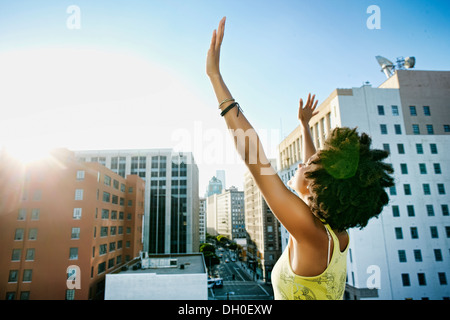 Mixed race woman on urban rooftop Stock Photo