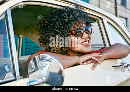 Mixed race woman sitting in vintage car Stock Photo