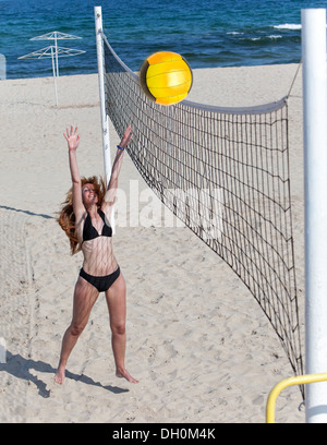 Attractive woman plays in beach volleyball Stock Photo