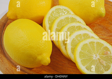 cut lemons at wooden board Stock Photo