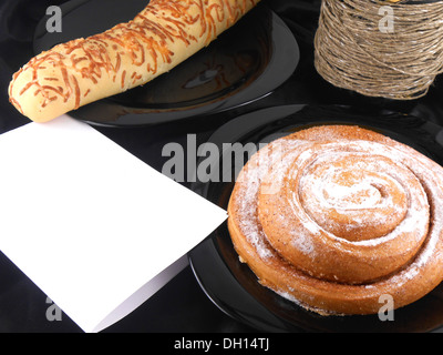 sweet cake on black background, white paper and wine bottle Stock Photo