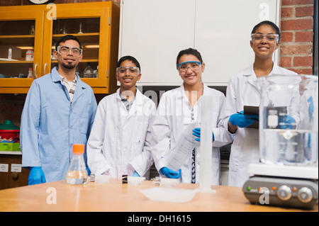Teacher and students smiling in science lab Stock Photo