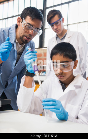 Teacher and students working in science lab Stock Photo