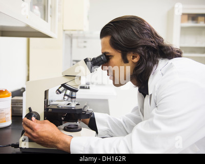 Indian scientist using microscope in laboratory Stock Photo