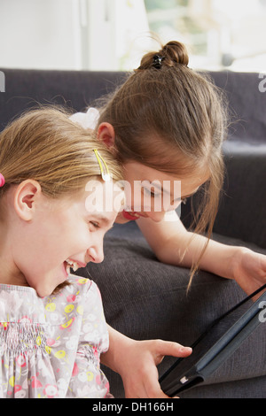 Two girls using digital tablet, Munich, Bavaria, Germany Stock Photo