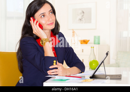 Mixed race businesswoman working at desk Stock Photo