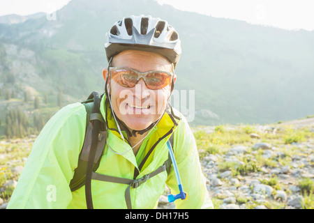 Caucasian man smiling on rocky trail Stock Photo