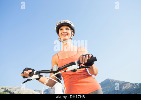 Caucasian woman pushing mountain bike Stock Photo