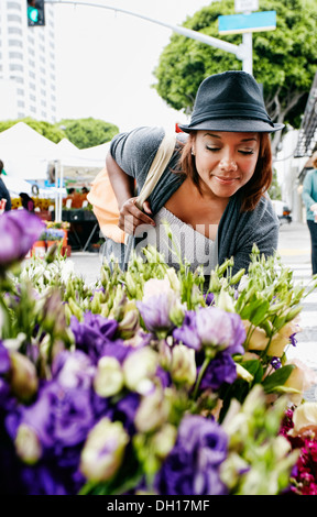 Black woman looking at flowers Stock Photo