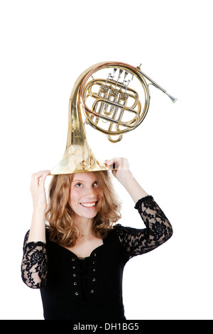 young woman playing with french horn against white background Stock Photo