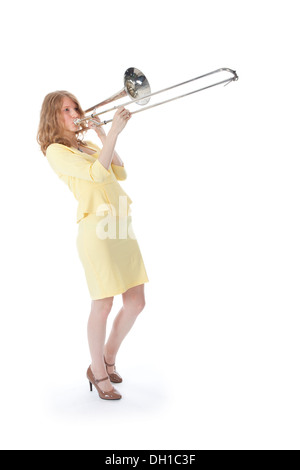 young woman in yellow playing trombone and white background Stock Photo