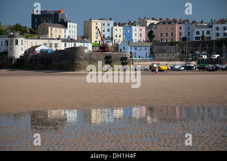 Coloured houses around Tenby harbour reflected on the wet beach. Stock Photo