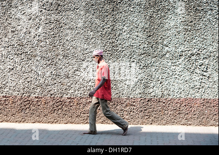 Man (Coolie) walking - street scene from Mumbai, Maharashtra Stock Photo