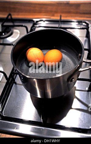 Two free range eggs boiling in a saucepan Stock Photo