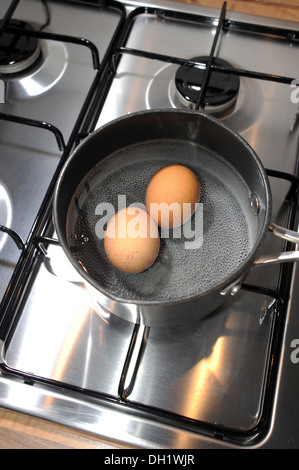 Two free range eggs boiling in a saucepan Stock Photo