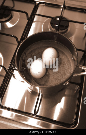 Two free range eggs boiling in a saucepan Stock Photo