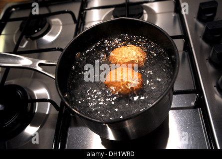 Two free range eggs boiling in a saucepan Stock Photo