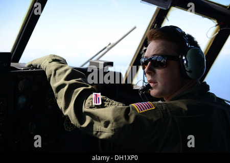 Lt. j.g. Matthew Chase scans the sky in a Coast Guard HC-130 Hercules airplane July 31, 2013. Chase graduated from the Coast Guard Academy in 2011 and subsequently fulfilled his lifelong dream of becoming a Hercules pilot. Stock Photo