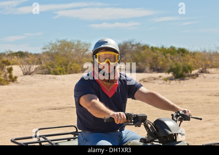 Male ATV Driver riding in the desert of Cabo San Lucas, Mexico Stock Photo