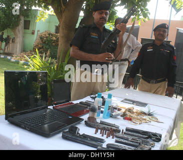 Karachi, Pakistan. 29th Oct, 2013. Police officials showing recovered weapons and robbed stuffs from criminals who arrested red handed during a robbery in Firozabad Police Station Limits, during a press conference at Senior Superintendent of Police, East Zone, Pir Muhammad Shah office in Karachi on Tuesday, October 29, 2013. © S.Imran Ali/PPI Images/Alamy Live News Stock Photo
