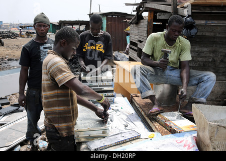 Teenage boys dismantle computer servers and other electronics to recover copper near the Agbogbloshie slum in Accra, Ghana Stock Photo