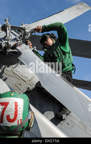 Aviation Machinist's Mate Airman Christopher McCarthy, assigned to the Wolf Pack of Helicopter Maritime Strike Squadron (HSM) 75, performs maintenance on an MH-60R Seahawk helicopter on the flight deck of the aircraft carrier USS Nimitz (CVN 68). Nimitz i Stock Photo