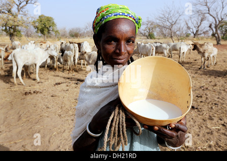 A Fulani woman presenting calabash with fresh milk, Burkina Faso Stock Photo