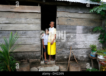 Girl and elderly woman standing at the entrance of her hut in a poor village, Chanero Rio, Provinz Jonuta, Tabasco, Mexico Stock Photo