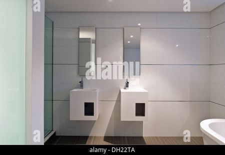 Rectangular mirrors above double basins in vanity units in modern white bathroom in newly built villa in southern Spain Stock Photo