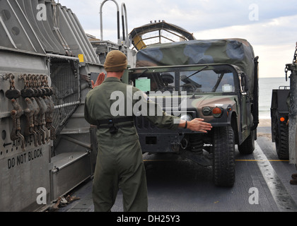 Boatswain's Mate 2nd Class Ethan Walton, a native of Roanoke, Va., directs a Humvee onto a landing craft air cushion Oct. 25 enroute to USS Bataan (LHD 5). Bataan sailors and 22nd Marine Expeditionary Unit Marines are underway conducting routine qualifica Stock Photo