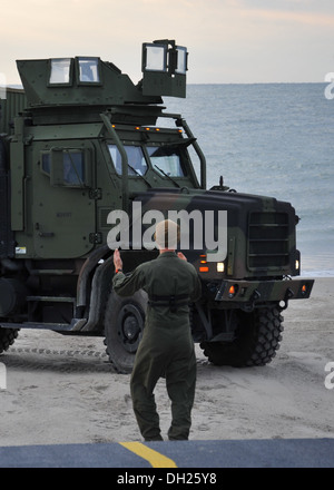 Boatswain's Mate 2nd Class Ethan Walton, a native of Roanoke, Va., directs an M-35 2 1/2 ton cargo truck on to a landing craft air cushion Oct. 25 enroute to USS Bataan (LHD 5). Bataan sailors and 22nd Marine Expeditionary Unit Marines are underway conduc Stock Photo