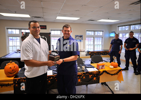 Capt. John Little the commander of Coast Guard Sector Hampton Roads, presents Petty Officer 2nd Class David Blonn, a food service specialist representing the Coast Guard Cutter Albacore, the chop champions trophy for winning the cooking competition, Monda Stock Photo