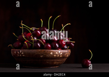 fresh cherries in bowl on wooden table Stock Photo