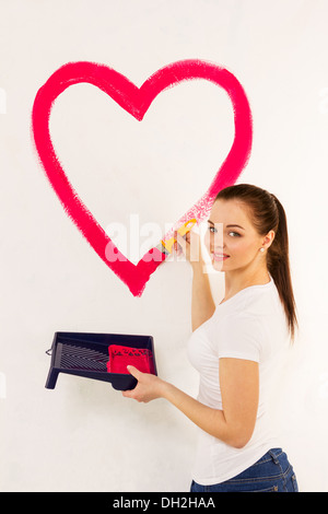 The young woman draws red paint heart Stock Photo